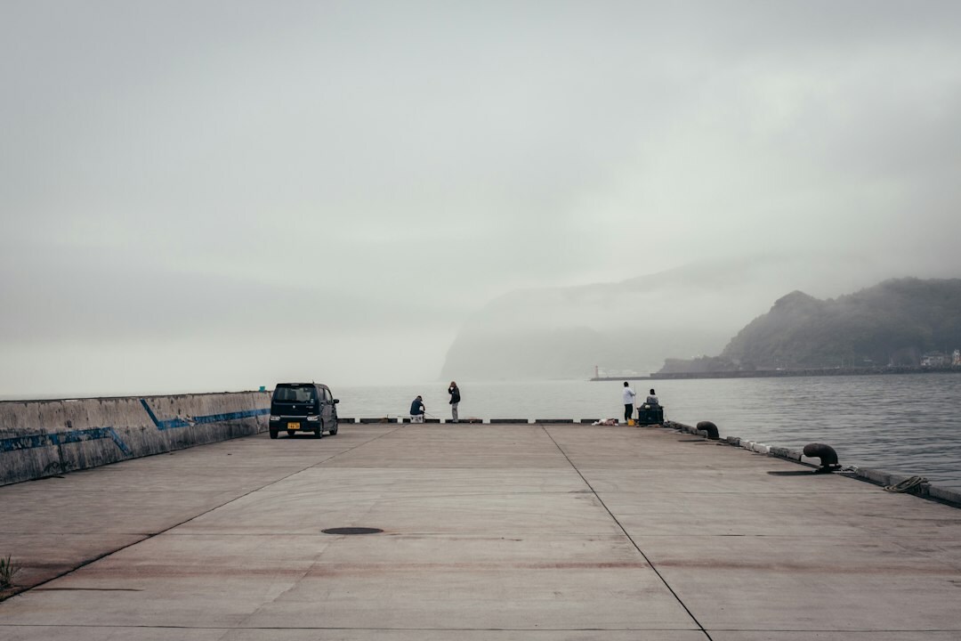 Fishermen mending nets on a pier in a small Chilean coastal town