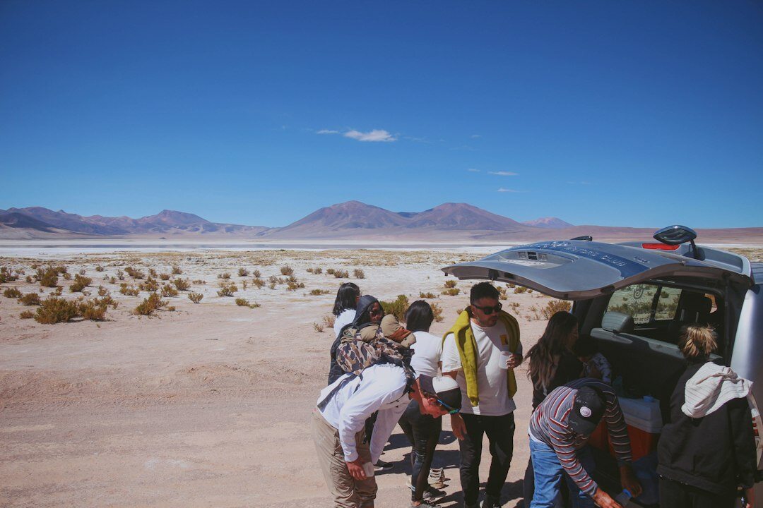 Rural bus stopped at a small station in the Atacama desert with passengers boarding