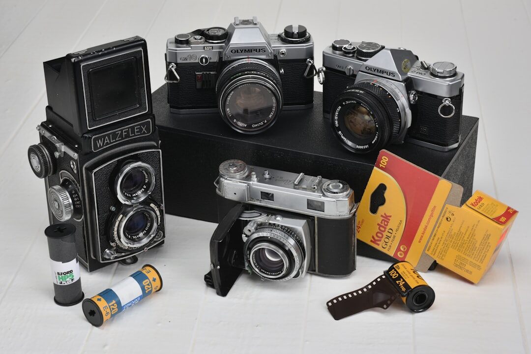 Old film cameras and contact sheets laid out on a wooden desk